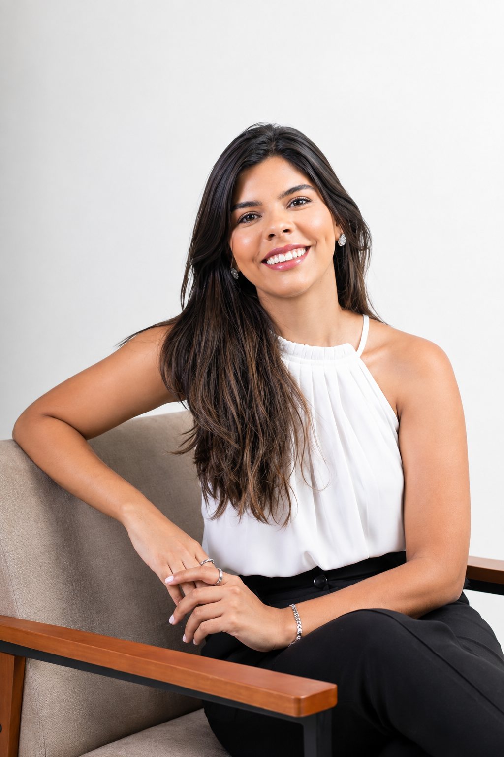 Dra. Kethelin Oliveira sorrindo, sentada em uma poltrona em ambiente claro